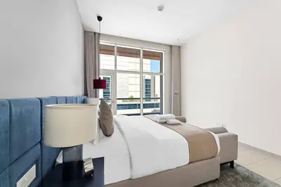 a bedroom with a large bed and a blue couch at Spacious 1-Bedroom Apartment In Bay Square in Dubai
