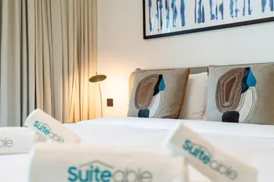 a hotel room with two beds with shoes on the pillows at Coastal Chic 1 Bedroom Apartment w private beach in Dubai