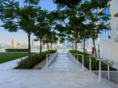 a walkway in front of a building with trees at Coastal Chic 1 Bedroom Apartment w private beach in Dubai