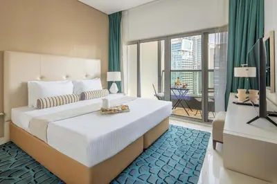 a bedroom with a large bed and a large window at Frank Porter - Damac Cour Jardin in Dubai