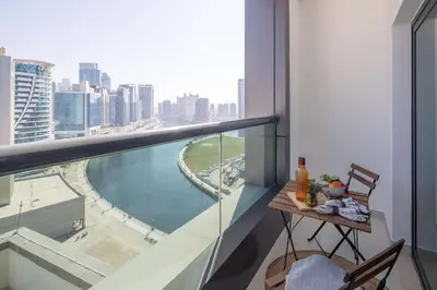 a balcony with a table and a view of a river at Frank Porter - Damac Cour Jardin in Dubai