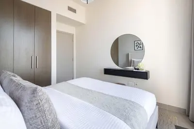 a bedroom with a white bed and a mirror at Frank Porter - Forte Tower 1 in Dubai