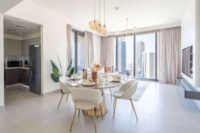 a dining room with a table and chairs and a kitchen at Frank Porter - Forte Tower 1 in Dubai