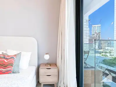 a bedroom with a bed and a balcony with a view at Urban Charm Studio with Balcony in Riviera in Dubai