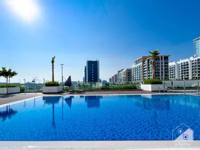 a large swimming pool with buildings in the background at Urban Charm Studio with Balcony in Riviera in Dubai