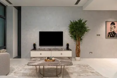 a living room with a tv on a wall at Skyline Burj Facing Suite in Dubai