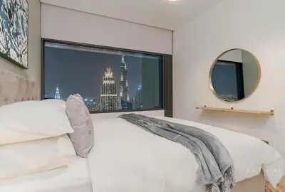 a bedroom with a window with a view of a city at Skyline Burj Facing Suite in Dubai