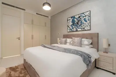 a bedroom with a large bed and a painting on the wall at Skyline Burj Facing Suite in Dubai