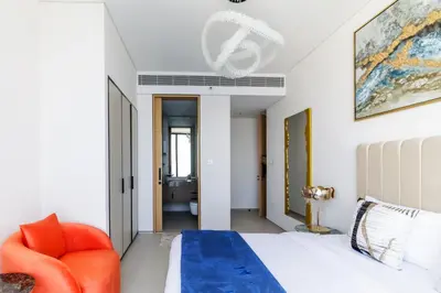 a bedroom with a bed and a orange chair at Panoramic Sea & Palm Views 2BR Address Beach Resort JBR in Dubai