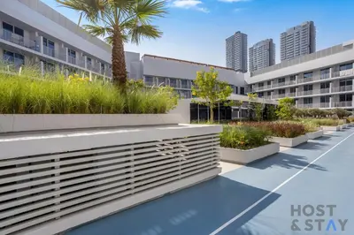 a view of a hospital building with a palm tree at Charming Studio in Luma 22, Jumeirah Village Circle in Dubai