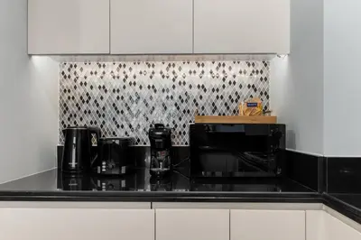 a kitchen with a black counter top with a microwave at Burj Khalifa Downtown Views - Highest Infinity Pool in Downtown in Dubai