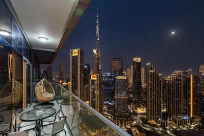 a view of a city skyline at night from a balcony at Burj Khalifa Downtown Views - Highest Infinity Pool in Downtown in Dubai