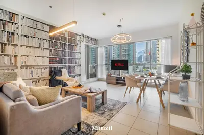 a living room with a large book wall with books at Stylish 2BR with Burj Khalifa View near Dubai Mall in Dubai