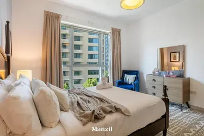 a bedroom with a bed with a window and a dresser at Stylish 2BR with Burj Khalifa View near Dubai Mall in Dubai