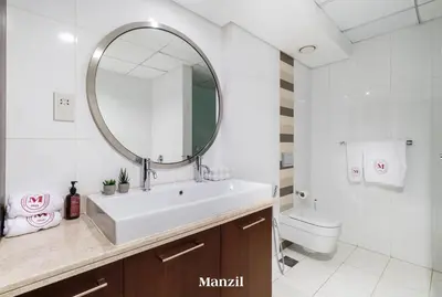 a bathroom with a sink and a mirror and a toilet at Stylish 2BR with Burj Khalifa View near Dubai Mall in Dubai