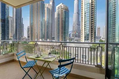 a balcony with a table and chairs and a view of a city at Stylish 2BR with Burj Khalifa View near Dubai Mall in Dubai
