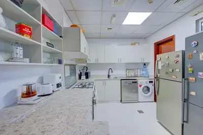 a kitchen with white appliances and white cabinets at Ramadan Staycation offers Miracle Home Haven in Dubai