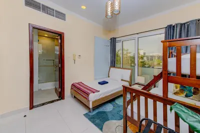 a small bedroom with a bed and a balcony at Ramadan Staycation offers Miracle Home Haven in Dubai