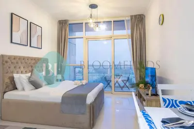 a bedroom with a bed and a large window at Bloomfields Stu In Carson in Dubai