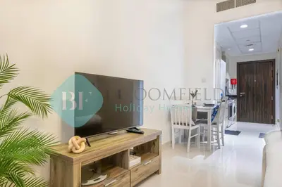 a living room with a flat screen tv on a wooden entertainment center at Bloomfields Stu In Carson in Dubai