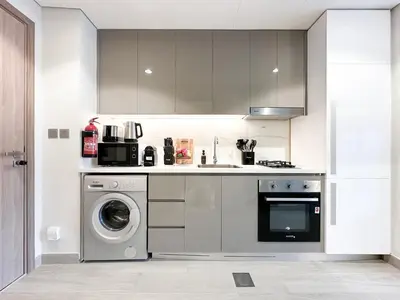 a kitchen with a washing machine and a dishwasher at Meydan Living - Unwavering Excellence in Dubai