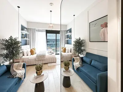a living room with two blue couches and two tables at Meydan Living - Unwavering Excellence in Dubai