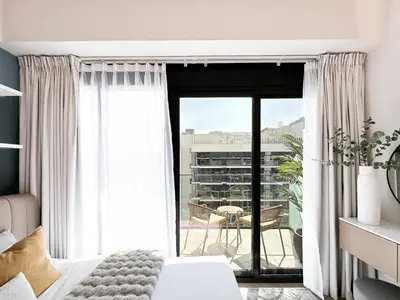 a bedroom with a bed and a view of a patio at Meydan Living - Unwavering Excellence in Dubai