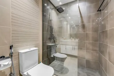 a bathroom with a toilet and a shower at Waves - Charming Studio with Lake Views Close to Metro in Dubai