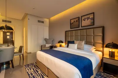 a bedroom with a large bed and a desk and a chair at GuestReady - Charming studio in Business Bay in Dubai