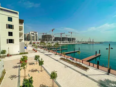 a sidewalk next to a body of water with a building at HiGuests - Beachfront Living Stunning 4 BR with Maid's Room in Dubai