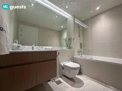 a bathroom with a toilet and a sink and a mirror at HiGuests - Beachfront Living Stunning 4 BR with Maid's Room in Dubai