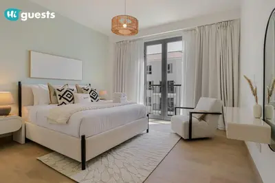 a white bedroom with a large bed and a chair at HiGuests - Beachfront Living Stunning 4 BR with Maid's Room in Dubai