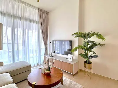 a living room with a couch and a tv at Luxe 2br With Fast Wi-fi Parking, Gym And Pool! in Dubai