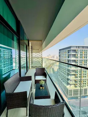 a balcony with a table and chairs on a building at Luxe 2br With Fast Wi-fi Parking, Gym And Pool! in Dubai