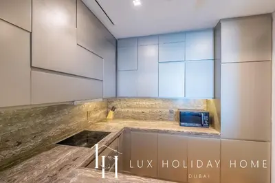 a kitchen with white cabinets and a microwave at LUX Lavish Suite with Full Marina View 4 in Dubai