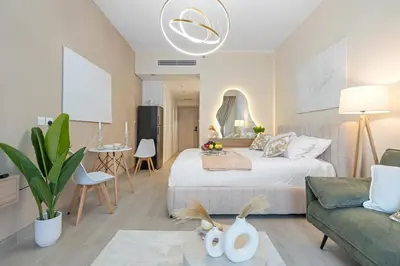 a bedroom with a bed and a living room at luxury Santorini studio style in Dubai