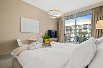 a white bedroom with a large bed and a window at luxury Santorini studio style in Dubai