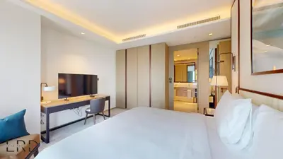 a bedroom with a bed and a desk and a television at Classy & Cozy 2BR Harbour Point in Dubai