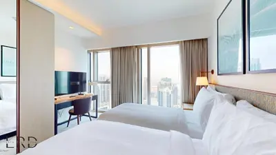 a hotel room with two beds and a desk at Classy & Cozy 2BR Harbour Point in Dubai