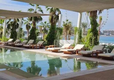 a swimming pool with lounge chairs and a resort at Lovely 1BD apartment in La Vie Dubai in Dubai