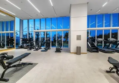 a gym with several treadmills and exercise equipment in a building at Lovely 1BD apartment in La Vie Dubai in Dubai