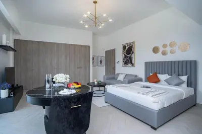 a bedroom with a bed and a table and a couch at Spacious and Modern Studio -Great Facilities in Dubai
