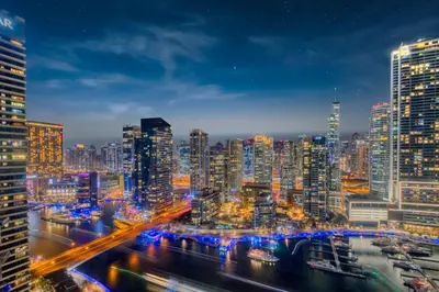 a view of a city at night with buildings at Marina Royale 3 Bedroom Apartment I Luxe Marina Harbour & Yacht Club Views I Nearby to a Beach I Free Pool, Gym, Wi-Fi and Parking I by Meerak in Dubai
