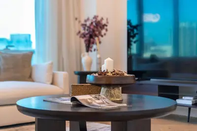 a living room with a table with a candle on it at Marina Royale 3 Bedroom Apartment I Luxe Marina Harbour & Yacht Club Views I Nearby to a Beach I Free Pool, Gym, Wi-Fi and Parking I by Meerak in Dubai