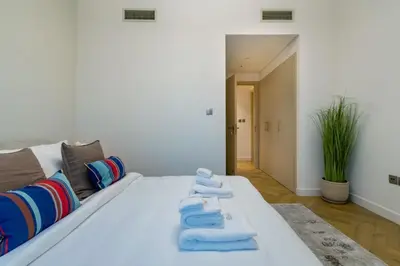 a white bed with towels on it in a room at Marina Royale 3 Bedroom Apartment I Luxe Marina Harbour & Yacht Club Views I Nearby to a Beach I Free Pool, Gym, Wi-Fi and Parking I by Meerak in Dubai