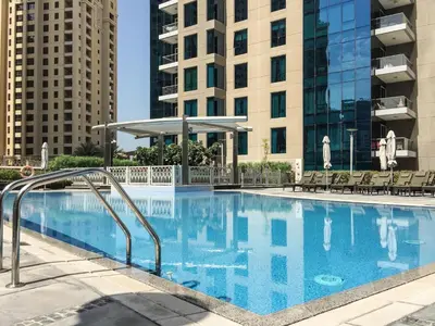 a swimming pool with chairs and buildings in the background at Marina Royale 3 Bedroom Apartment I Luxe Marina Harbour & Yacht Club Views I Nearby to a Beach I Free Pool, Gym, Wi-Fi and Parking I by Meerak in Dubai