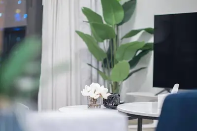 a vase of flowers on a table with a plant at Dubai Opera - Luxury 2 Bedroom Apartment - Near Burj Khalifa in Dubai