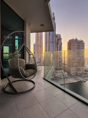 a chair on a balcony with a view of a city at 2BR Luxury Retreat - Stunning Canal and Sea View in Dubai