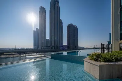 a swimming pool in the middle of a city with tall buildings at 2BR Luxury Retreat - Stunning Canal and Sea View in Dubai