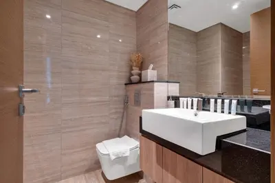 a bathroom with a white sink and a toilet at 2BR Luxury Retreat - Stunning Canal and Sea View in Dubai